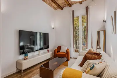 a white living room with a large flat screen tv at Amplio Apartamento en Barcelona in Barcelona