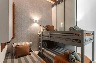 a bunk room with two bunk beds and a mirror at Amplio Apartamento en Barcelona in Barcelona