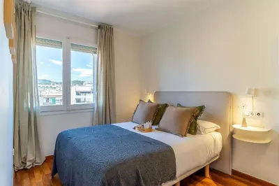 a bedroom with a bed with a blue blanket and a window at 4329 - AB Eixample Centric in Barcelona