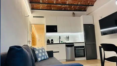 a living room with a couch and a kitchen at Bajos con encanto by Prestigi in Terrassa