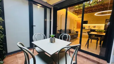 a white table and chairs on a balcony with a living room at Bajos con encanto by Prestigi in Terrassa
