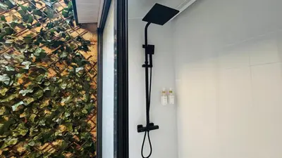 a shower in a bathroom with a green wall at Bajos con encanto by Prestigi in Terrassa
