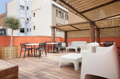 a patio with tables and chairs on a building at Enjoybcn Colon Apartments in Barcelona