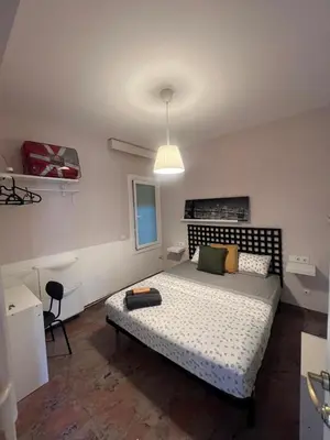 a bedroom with a bed and a pendant light at Una estancia temporal en un sitio ideal y céntrico de Barcelona in Barcelona