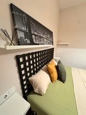 a bedroom with a green bed with pillows on it at Una estancia temporal en un sitio ideal y céntrico de Barcelona in Barcelona