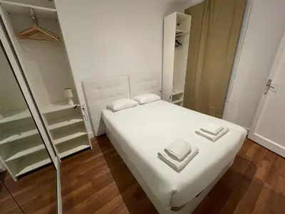 a small bedroom with a white bed and a closet at Practical, 3 double bedrooms, 7' Sagrada Familia in Barcelona