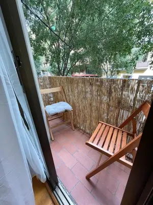 a patio with a wooden bench and a chair at Practical, 3 double bedrooms, 7' Sagrada Familia in Barcelona