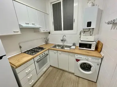 a small kitchen with a sink and a washing machine at Practical, 3 double bedrooms, 7' Sagrada Familia in Barcelona