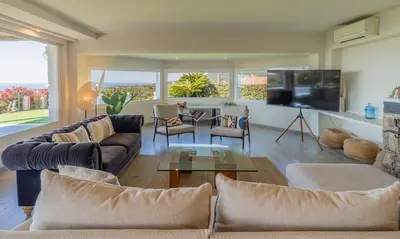 a living room with two couches and a tv at Casanova, villa with Barcelona's skyline in Cabrils