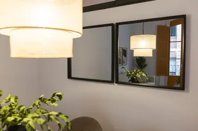 two lamps and a mirror on a wall at Barcelona - Gracia P-A in Barcelona