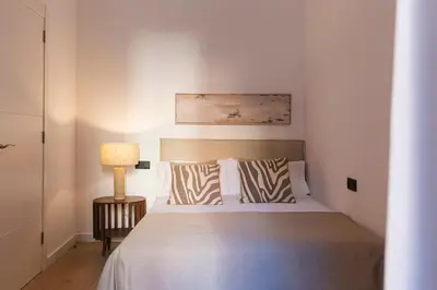 a bedroom with a bed and a lamp on a table at Barcelona - Gracia P-A in Barcelona