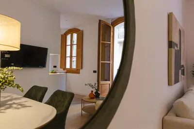 a living room with a table and chairs and a mirror at Barcelona - Gracia P-B in Barcelona