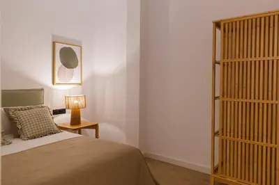 a bedroom with a bed and a table with a lamp at Barcelona - Gracia P-B in Barcelona