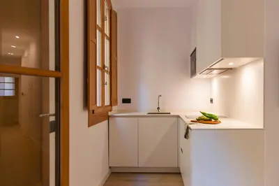 a kitchen with white cabinets and a sink at Barcelona - Gracia P-B in Barcelona