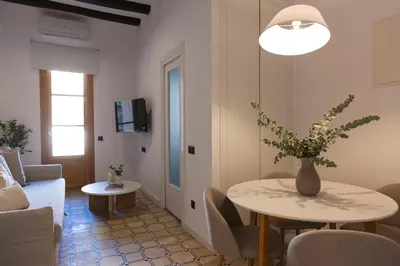 a living room with a table with a vase of flowers on it at Barcelona - Gracia 1-A in Barcelona
