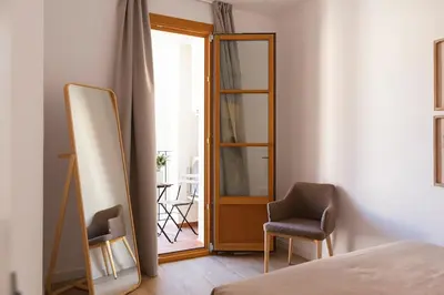 a bedroom with a mirror and two chairs and a bed at Barcelona - Gracia 2-B in Barcelona