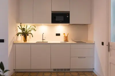 a white kitchen with a sink and a microwave at Barcelona - Gracia 4-B in Barcelona