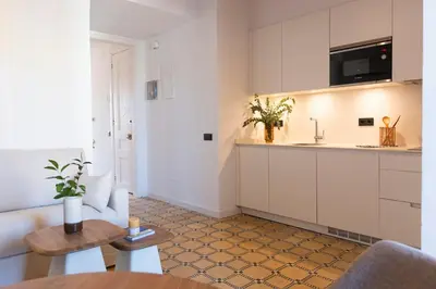 a kitchen with white cabinets and a table at Barcelona - Gracia 4-B in Barcelona