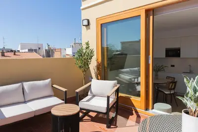a balcony with a couch and chairs and a table at Barcelona - Gracia 5-A in Barcelona