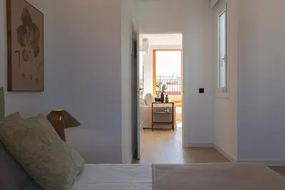 a bedroom with a bed and a living room with a window at Barcelona - Gracia 5-A in Barcelona