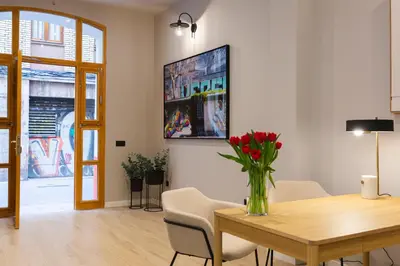 a dining room with a table and a vase with red flowers at Barcelona - Gracia 5-B in Barcelona