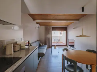 a kitchen with a wooden table and red chairs at Casa Flor Boutique Mid-term Monthly Rentals in Barcelona