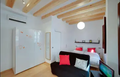 a bedroom with a bed and a couch with red pillows at Barceloneta Beach 1 in Barcelona
