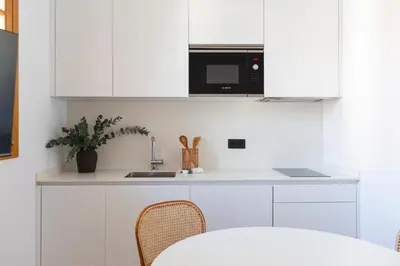 a white kitchen with a sink and a microwave at Barcelona - Gracia 3-B in Barcelona