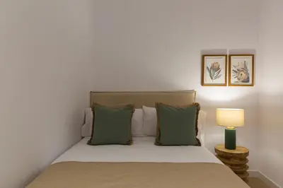 a bedroom with a bed with green pillows and a lamp at Barcelona - Gracia 3-B in Barcelona
