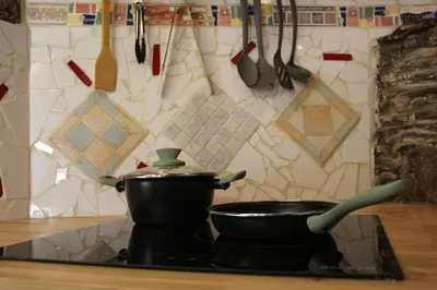 a pot on top of a stove with utensils at 3-Story Gaudi Building with Montserrat Stone in Monistrol