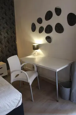 a bedroom with a desk with a lamp and two chairs at 3-Story Gaudi Building with Montserrat Stone in Monistrol