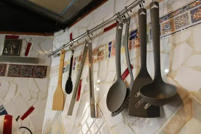 a group of utensils hanging on a wall at 3-Story Gaudi Building with Montserrat Stone in Monistrol