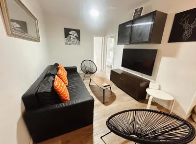a living room with a black leather couch and a flat screen tv at 2 bedrooms apartment in Barcelona F1 in Hospitalet de Llobregat