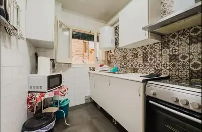 a small kitchen with a stove and a microwave at Apartamento de 3 habitaciones en Barcelona F2 in Hospitalet de Llobregat