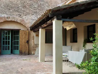 a patio with a table and chairs in a building at Accommodation in a 13th century Catalan farmhouse in Terrassa