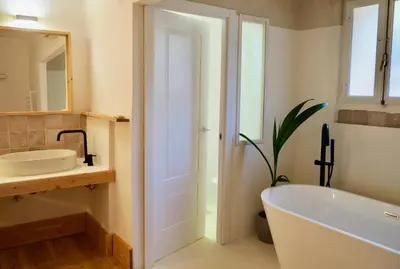 a bathroom with a tub and a sink and a mirror at Accommodation in a 13th century Catalan farmhouse in Terrassa