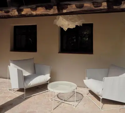 two white chairs and a table in a room at Accommodation in a 13th century Catalan farmhouse in Terrassa