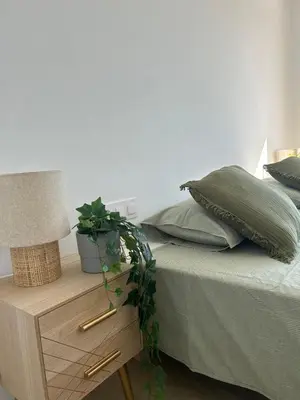 a bedroom with a bed with a table with a lamp at Les Flors de Cunit Villa Cedra in Cunit