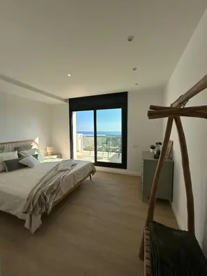 a bedroom with a large bed and a large window at Les Flors de Cunit Villa Cedra in Cunit