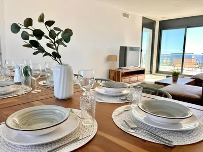 a dining room table with plates and glasses on it at Les Flors de Cunit Villa Cedra in Cunit