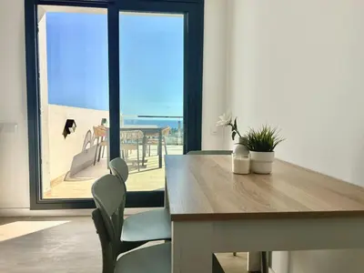 a dining table and chairs with a view of the ocean at Les Flors de Cunit Villa Cedra in Cunit