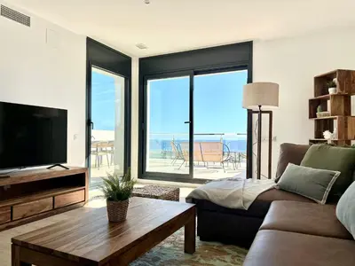 a living room with a couch and a tv and a table at Les Flors de Cunit Villa Cedra in Cunit