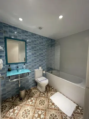a bathroom with a tub and a toilet and a sink at Hostal Nova Barcelona in Barcelona