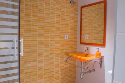 a yellow tiled bathroom with a sink and a mirror at Hostal Nova Barcelona in Barcelona