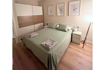 a bedroom with a bed with a green bedspread at Sunny & remodeled Apartment in Sant Boi del Llobregat