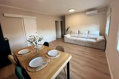 a dining room with a table and a couch at Sunny & remodeled Apartment in Sant Boi del Llobregat