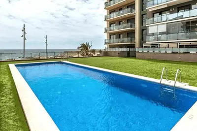 a swimming pool in front of a building at Great apartment with a pool on the beach in Barcelona in Badalona