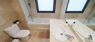 a bathroom with a toilet and a sink and a tub at Great apartment with a pool on the beach in Barcelona in Badalona
