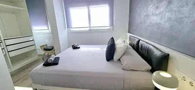 a bedroom with a large bed with pillows and a window at Ideal for families on the beach in Barcelona with a pool in Badalona