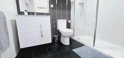 a white bathroom with a toilet and a shower at Ideal for families on the beach in Barcelona with a pool in Badalona
